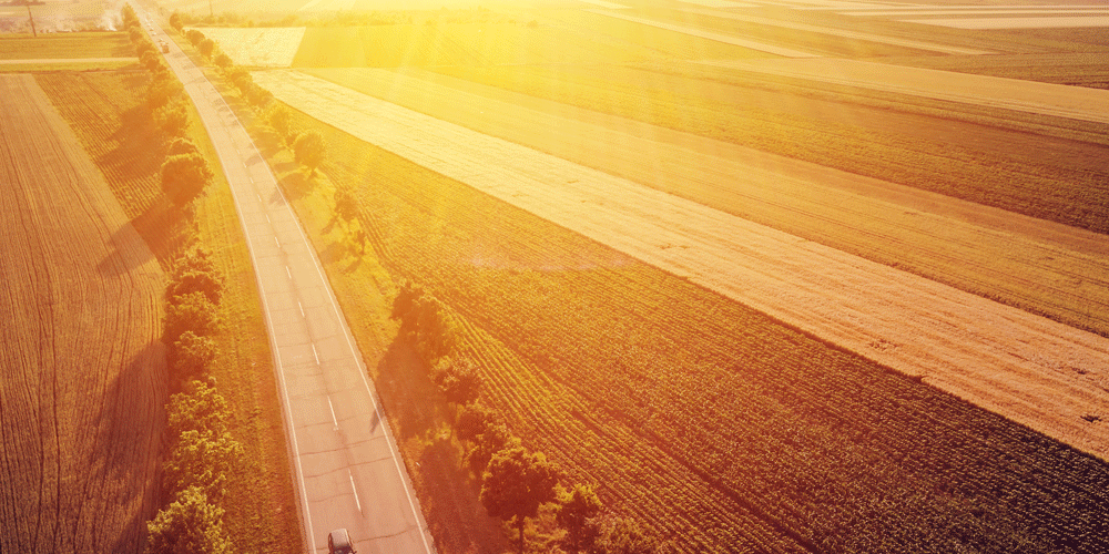 Overhead shot of sunny, rural roadways; understanding truck driver pay; ATS; Anderson Trucking Service