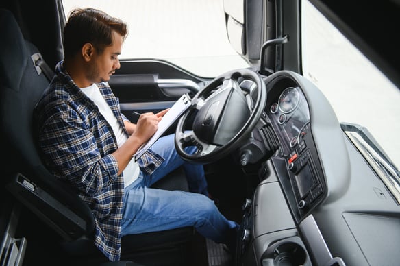 man-completes-paperwork-in-the-cab-of-a-truck, how to calculate recap hours, trucking, ATS