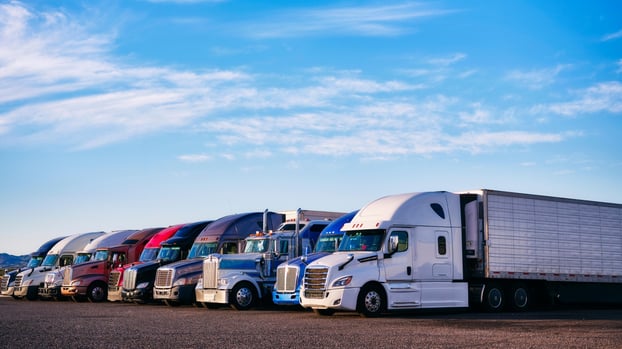 row-of-semi-trucks-parked-against-a-blue-sky; best paying trucking companies; ATS; Anderson Trucking Service