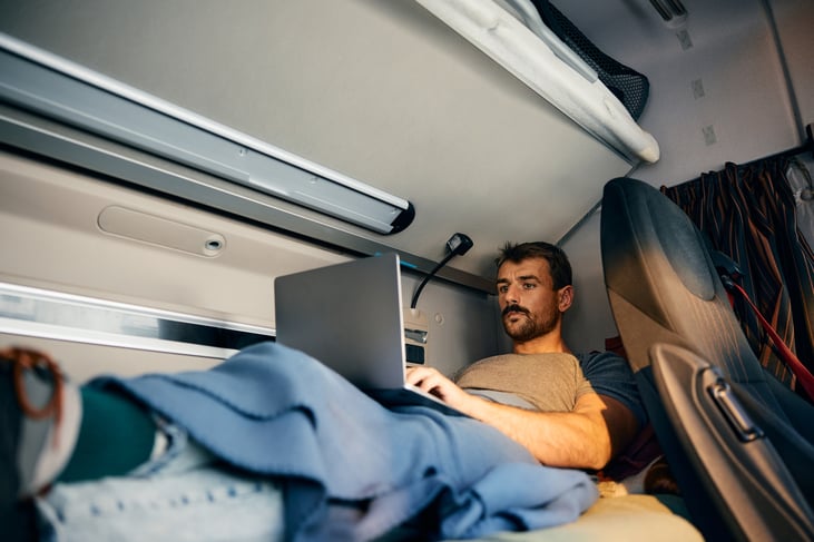 A trucker uses his laptop for entertainment while stopped overnight