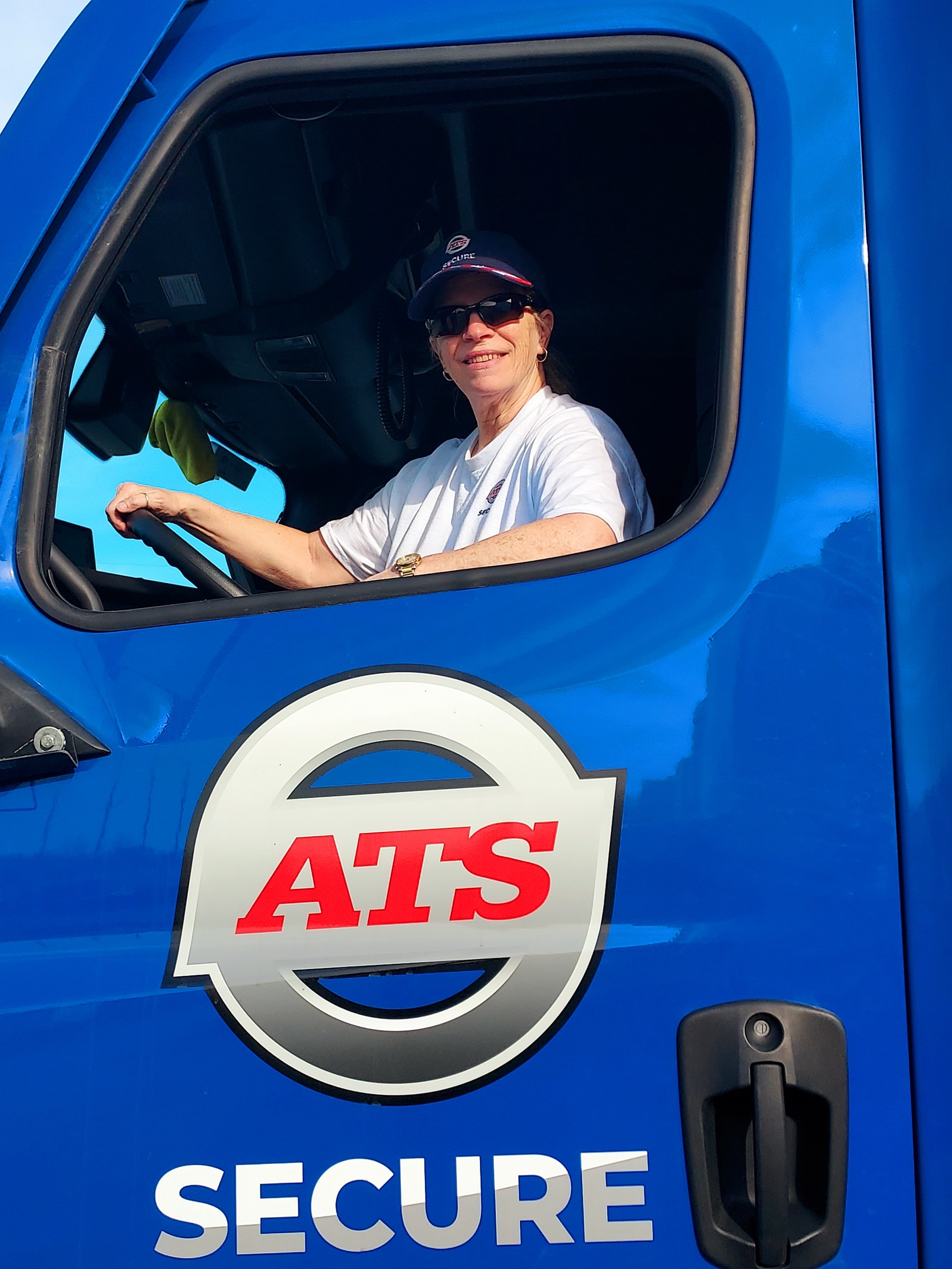 ATS Secure driver, Melissa Pollock, smiles from the cab of her truck